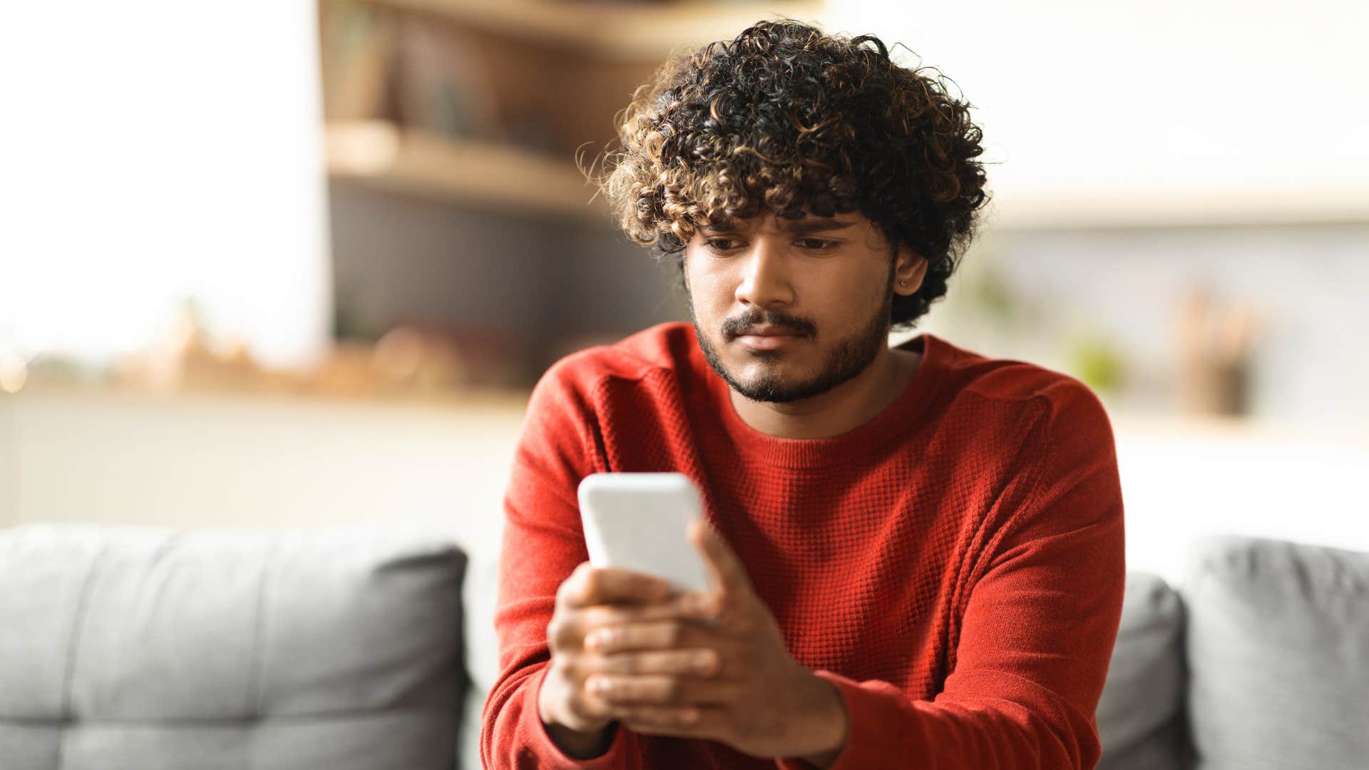 sad man looking at his phone texting i'm not usually invited to things