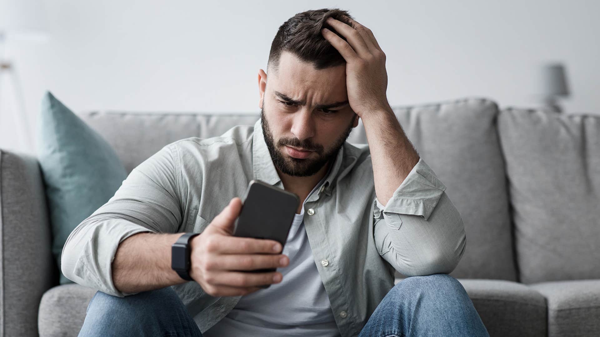man looking at phone overthinking everything