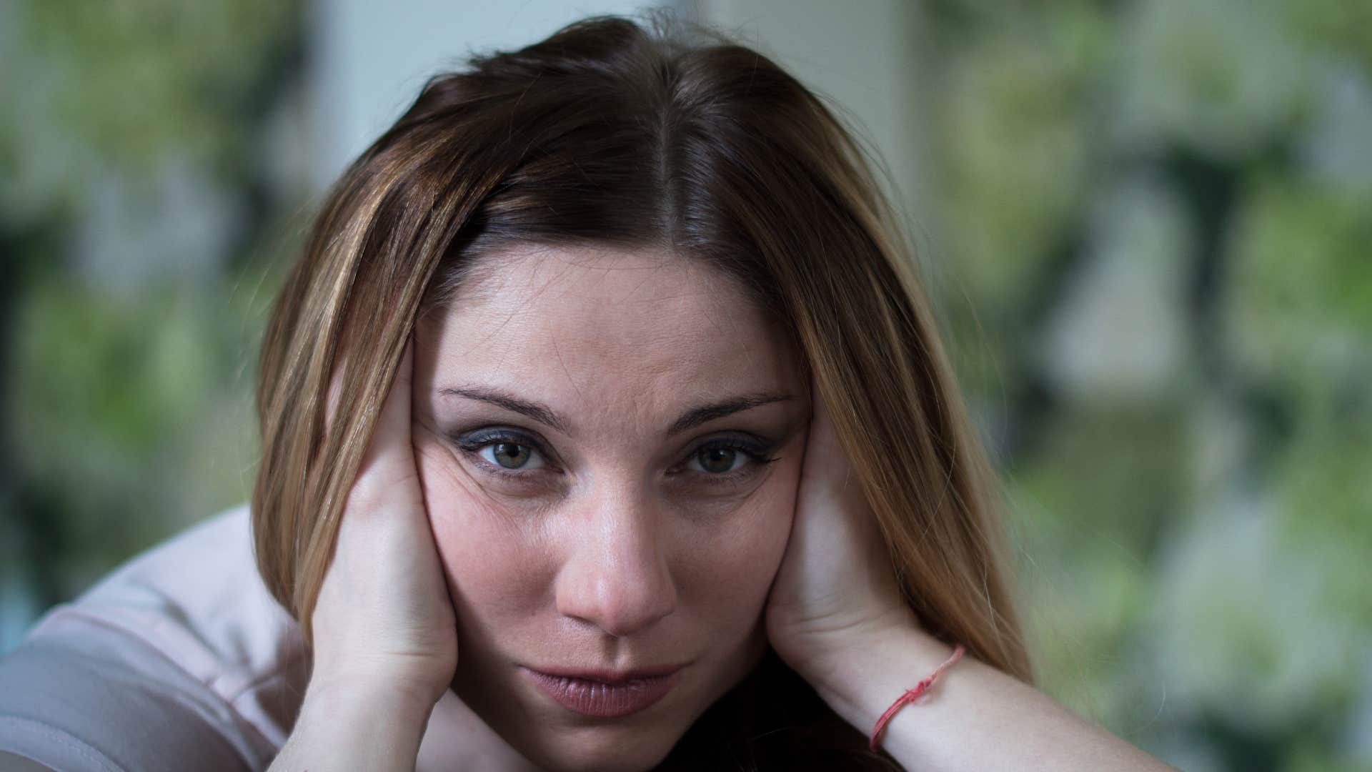 Self-defeating woman hold both sides of head showing trait men never attracted to