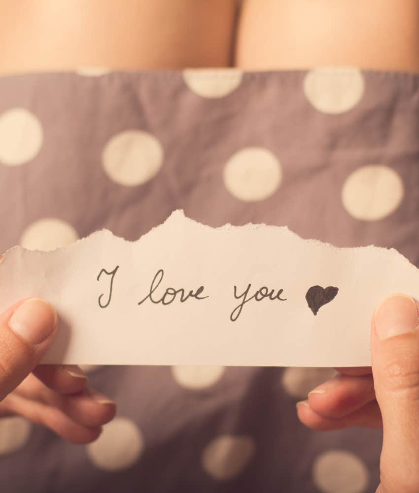 Hands holding note that says I love you 