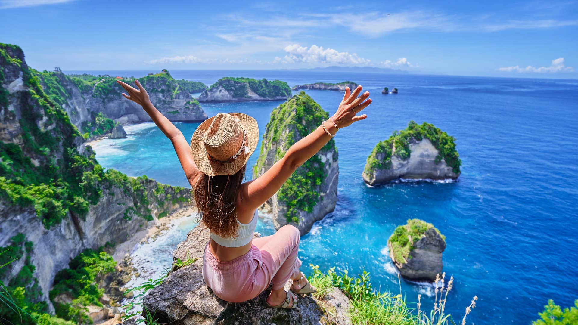 Excited person sits on cliff over sea showing admired people know themselves