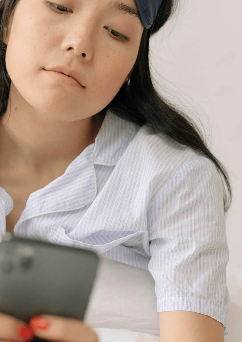 serious woman looking down at her phone