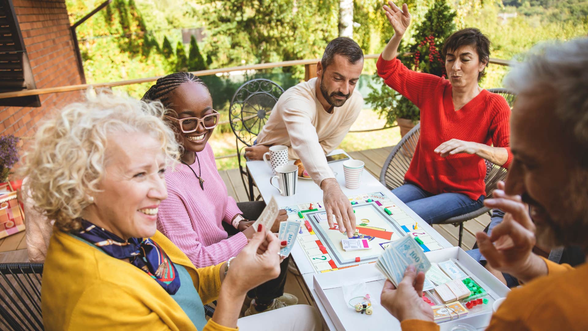 Happy friends play board game showing community post-divorce