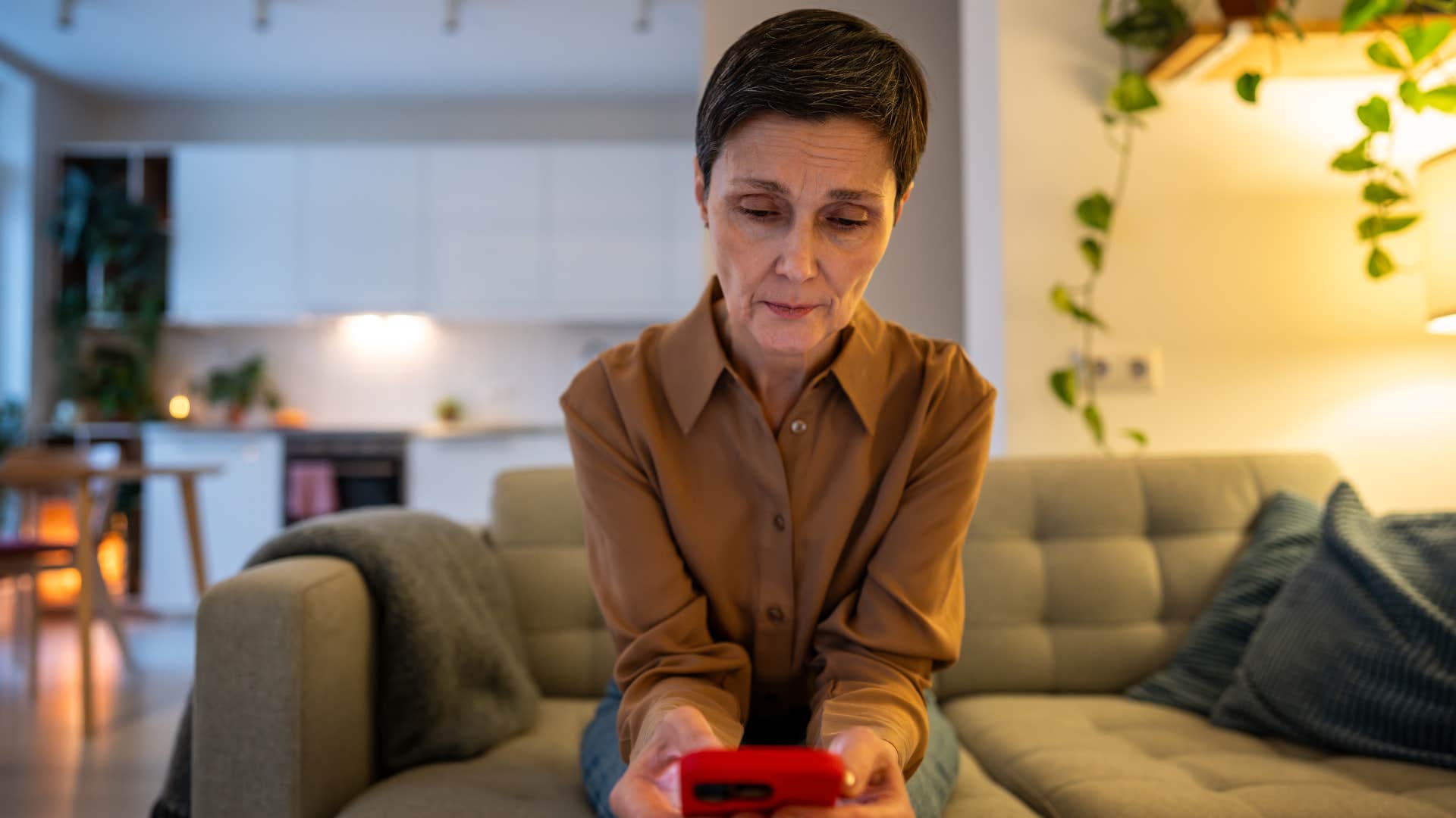 lonely woman looking at phone to call a friend