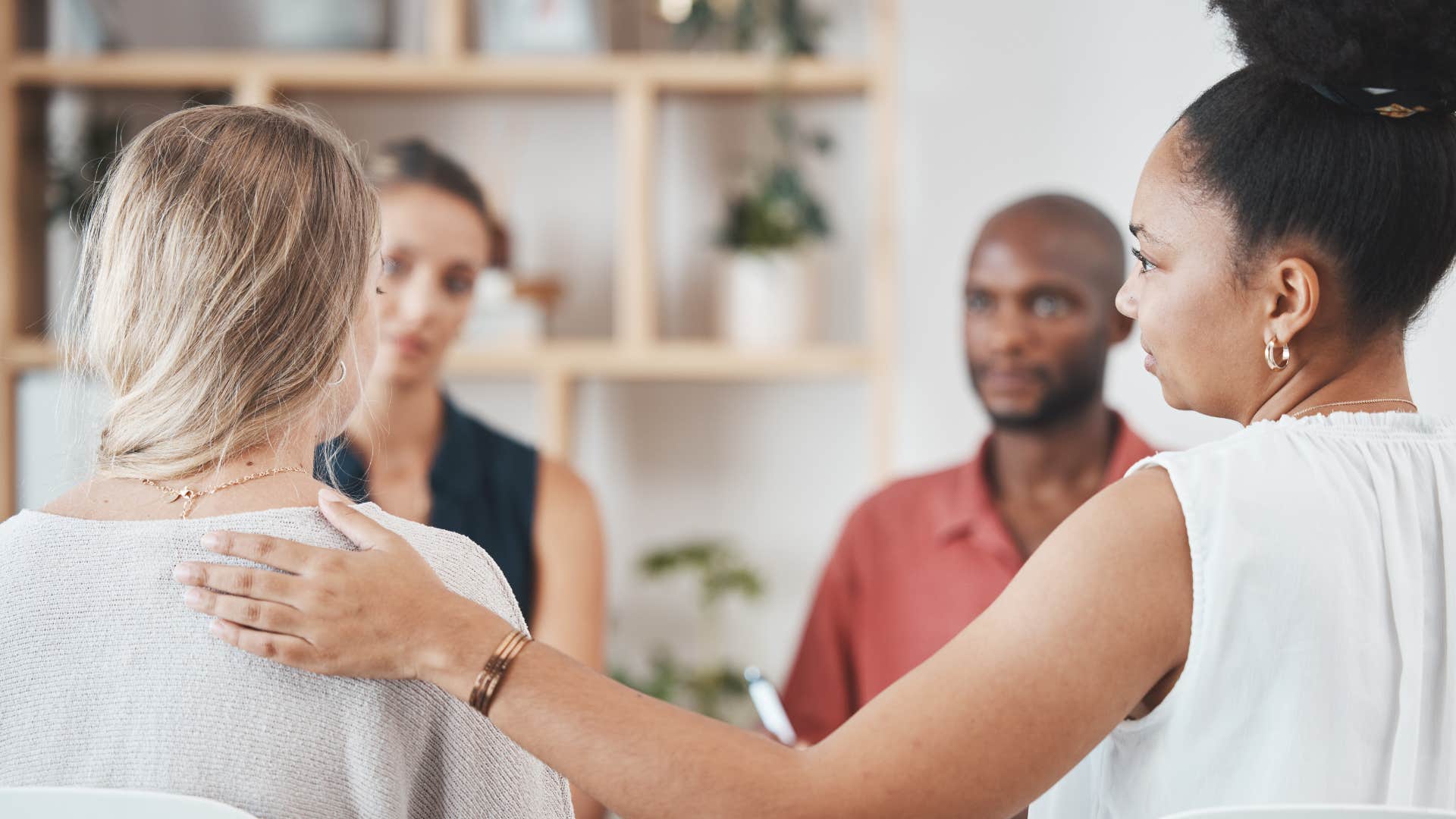 lonely woman being comforted by group