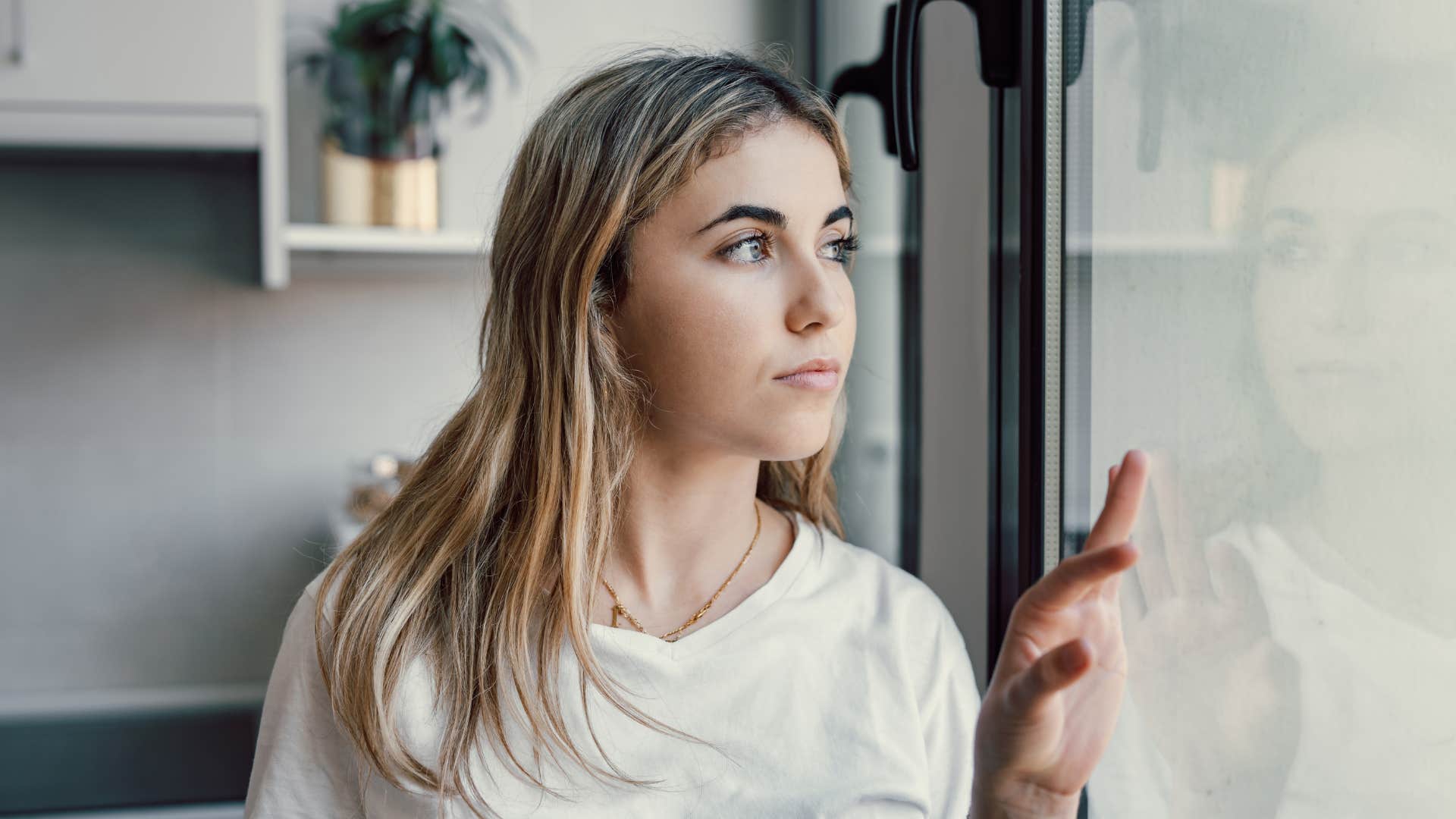 lonely woman looking outside thinking