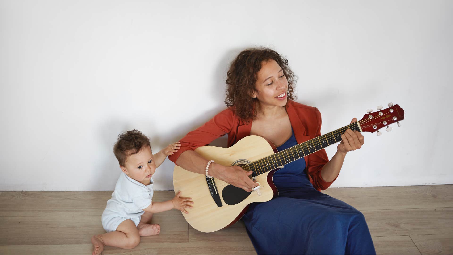 Joyful person plays guitar for baby showing way to be happier