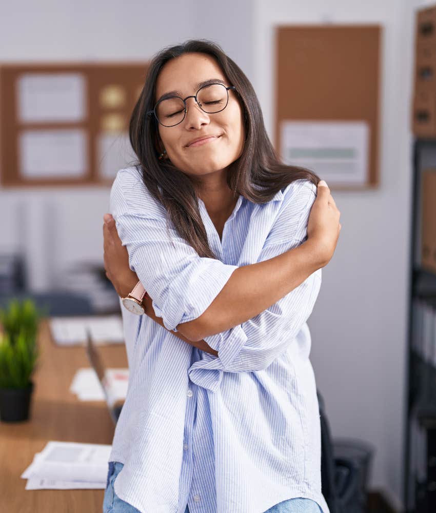 Calm person hugs self showng way to protect heart