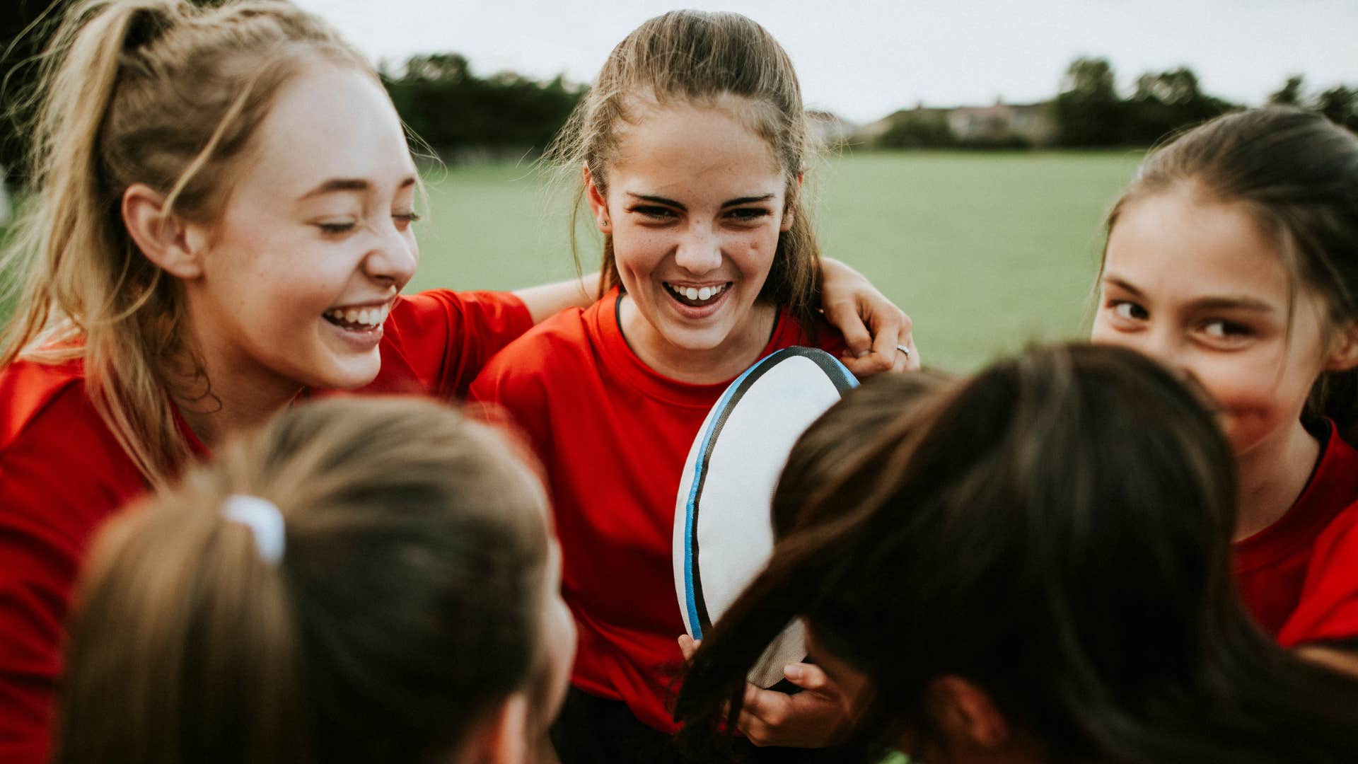 group of young girls playing rugby as extracurricular activity