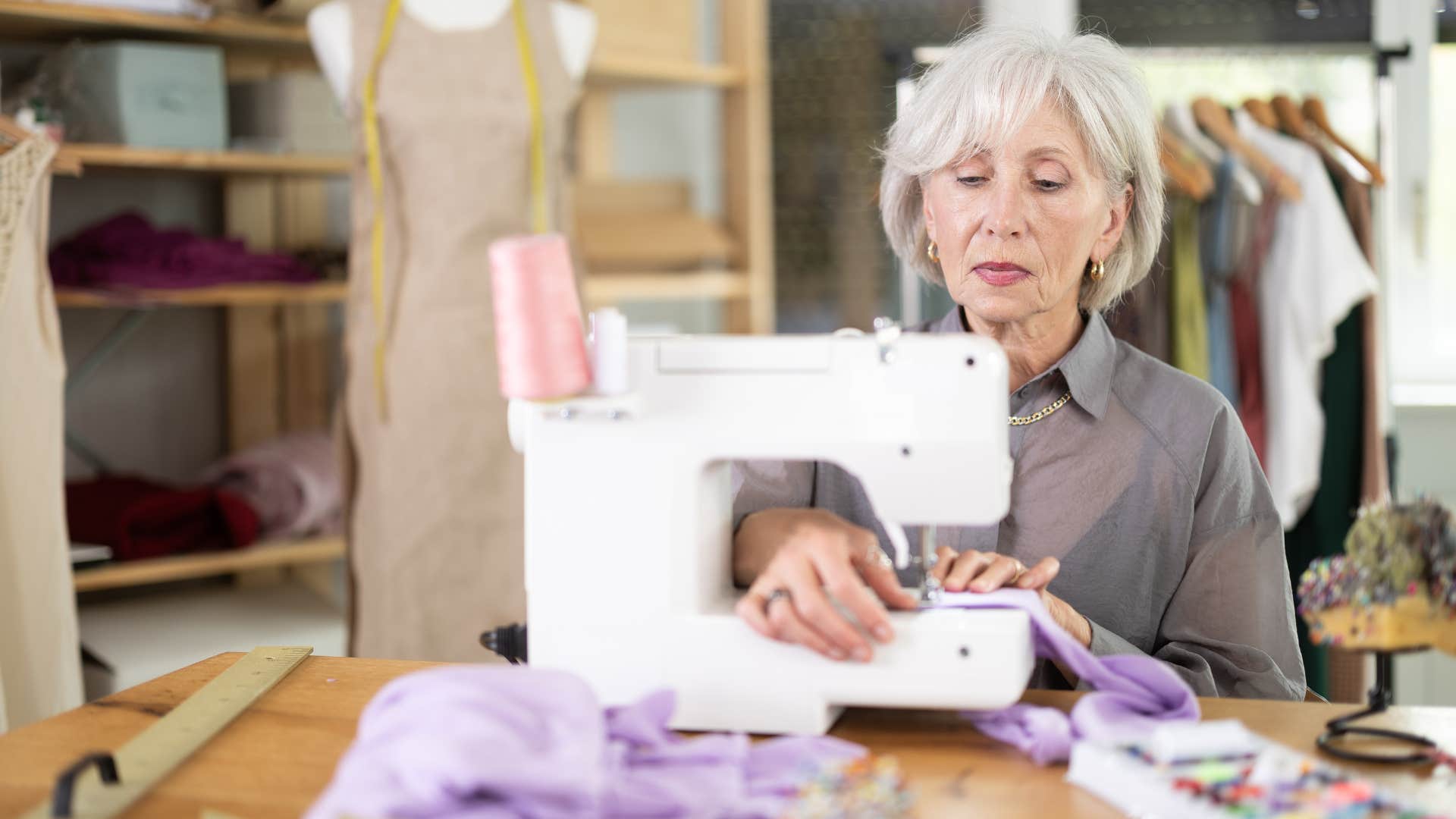 older woman sewing new clothes at home