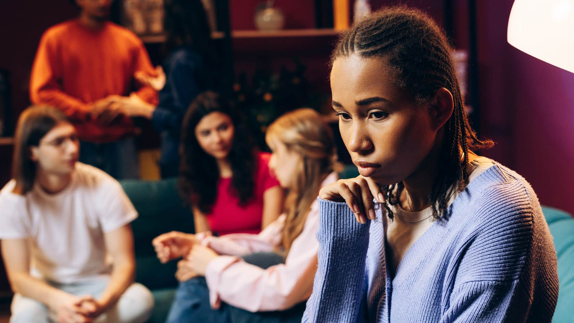 Upset person separates from group showing friends make them feel worse