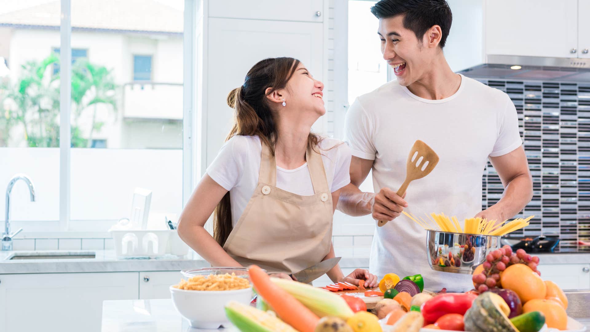 happy couple working as a team to make dinner