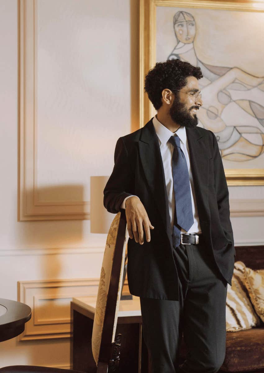 smiling professional man leaning against a chair