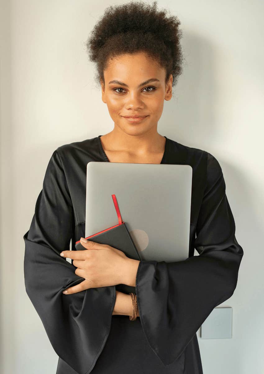 smiling woman holding laptop