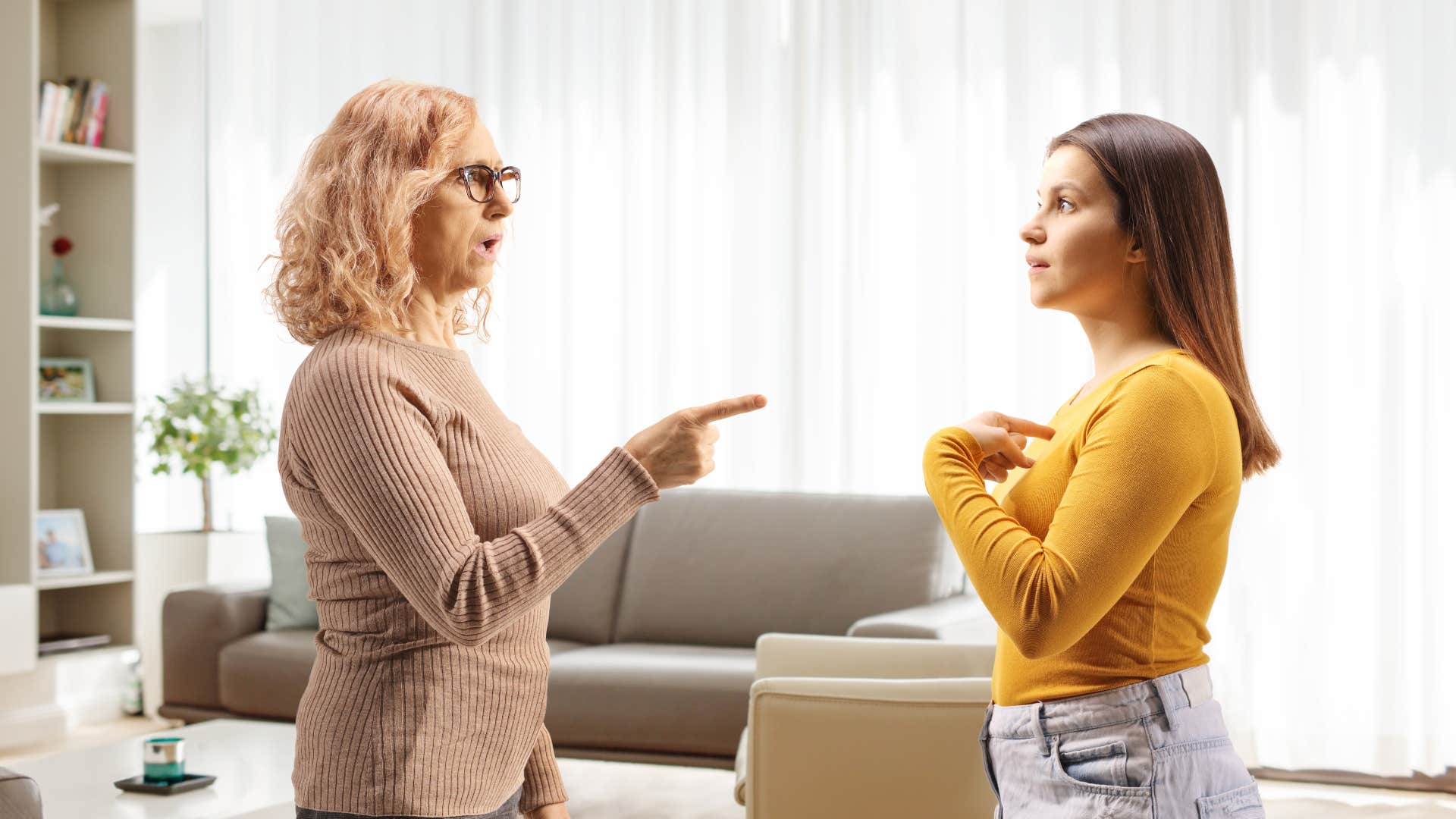 woman pointing finger at daughter not taking her seriously
