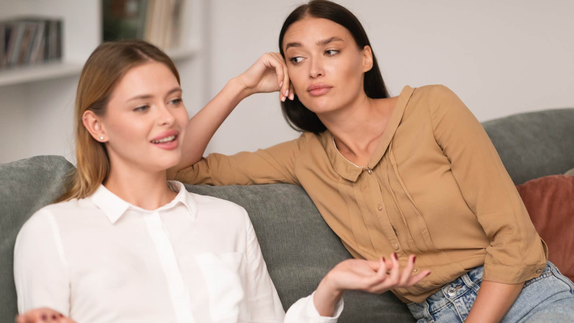 woman having redundant conversation while friend looks annoyed
