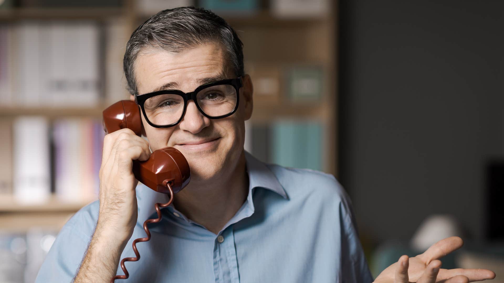 man in blue on phone saying everyone else is fine with it while shrugging