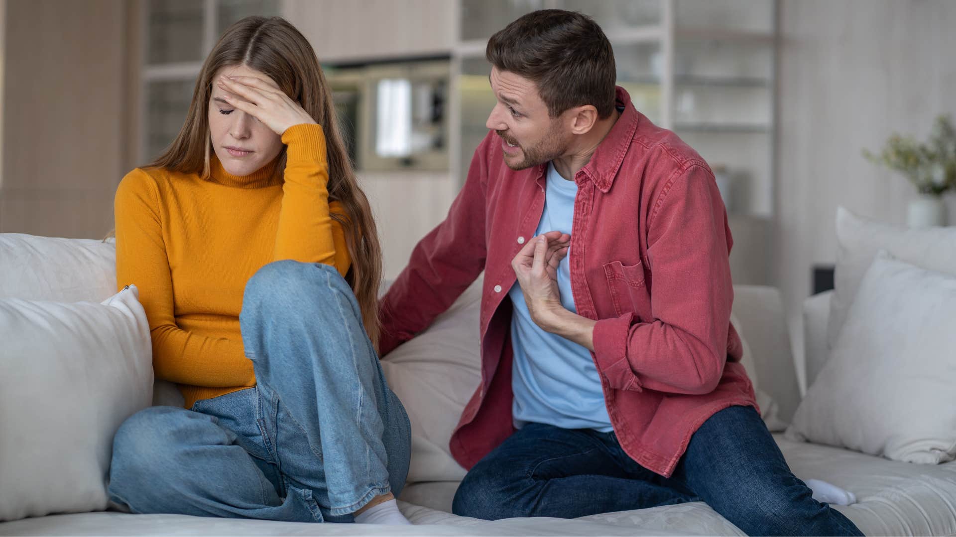 man pointing at himself as he said that's not what i meant to woman