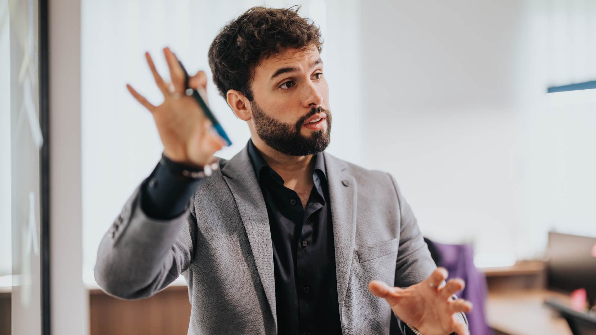 man holding up hand as person tries to micromanage him