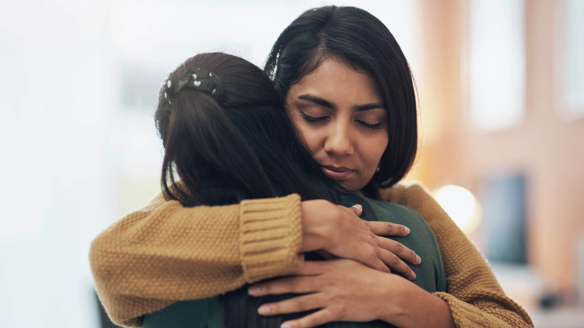 woman hugging overly emotional person as she does her best to comfort