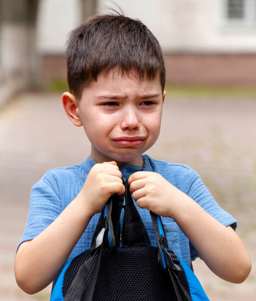 Crying boy clutches bag to chest showing thing not to overcomplicate raising boys