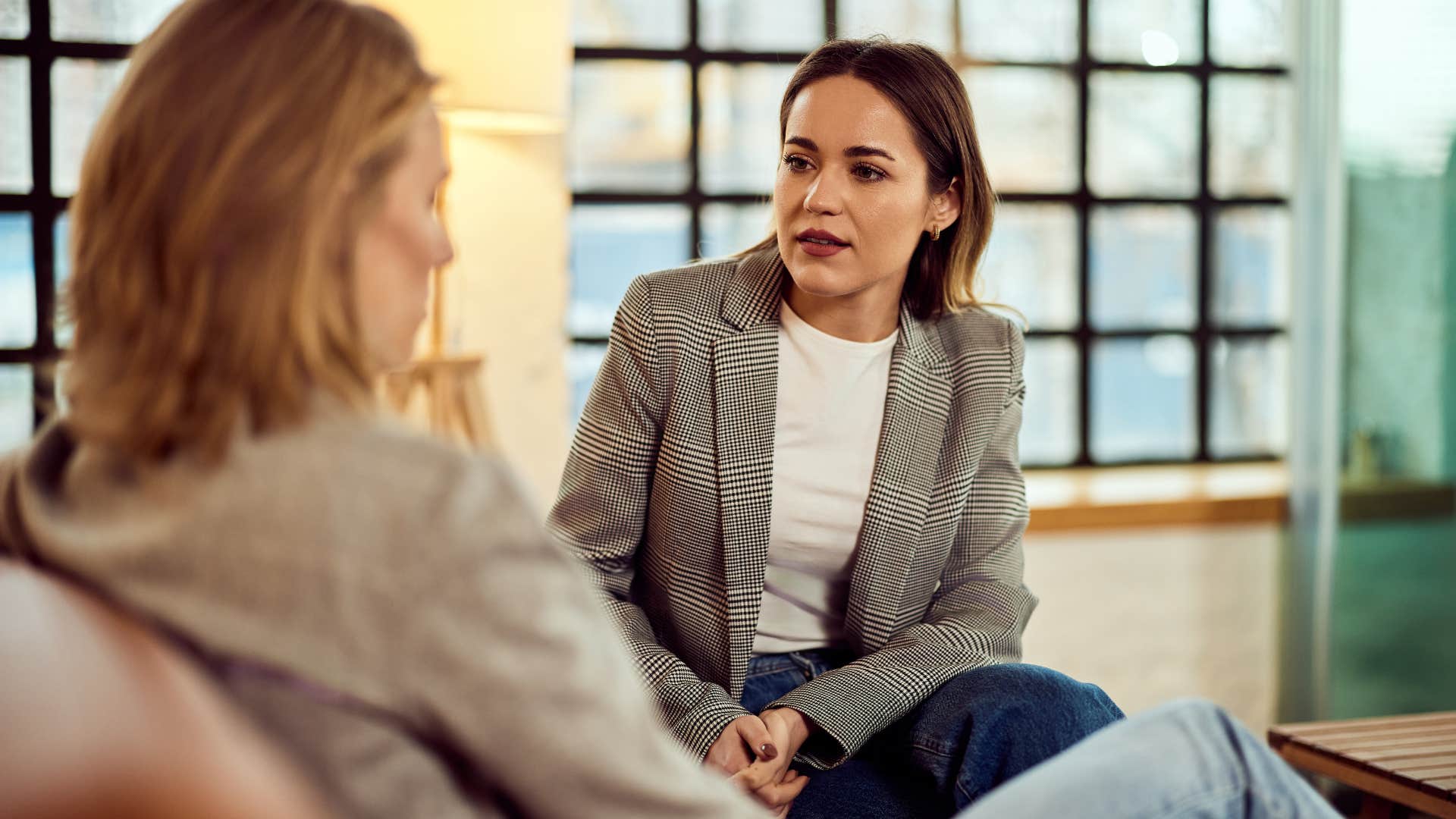 Woman commenting on a person's body with a friend.