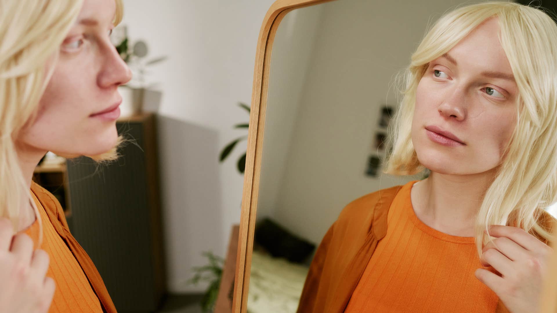 Woman thinking about diet culture in the mirror at home.