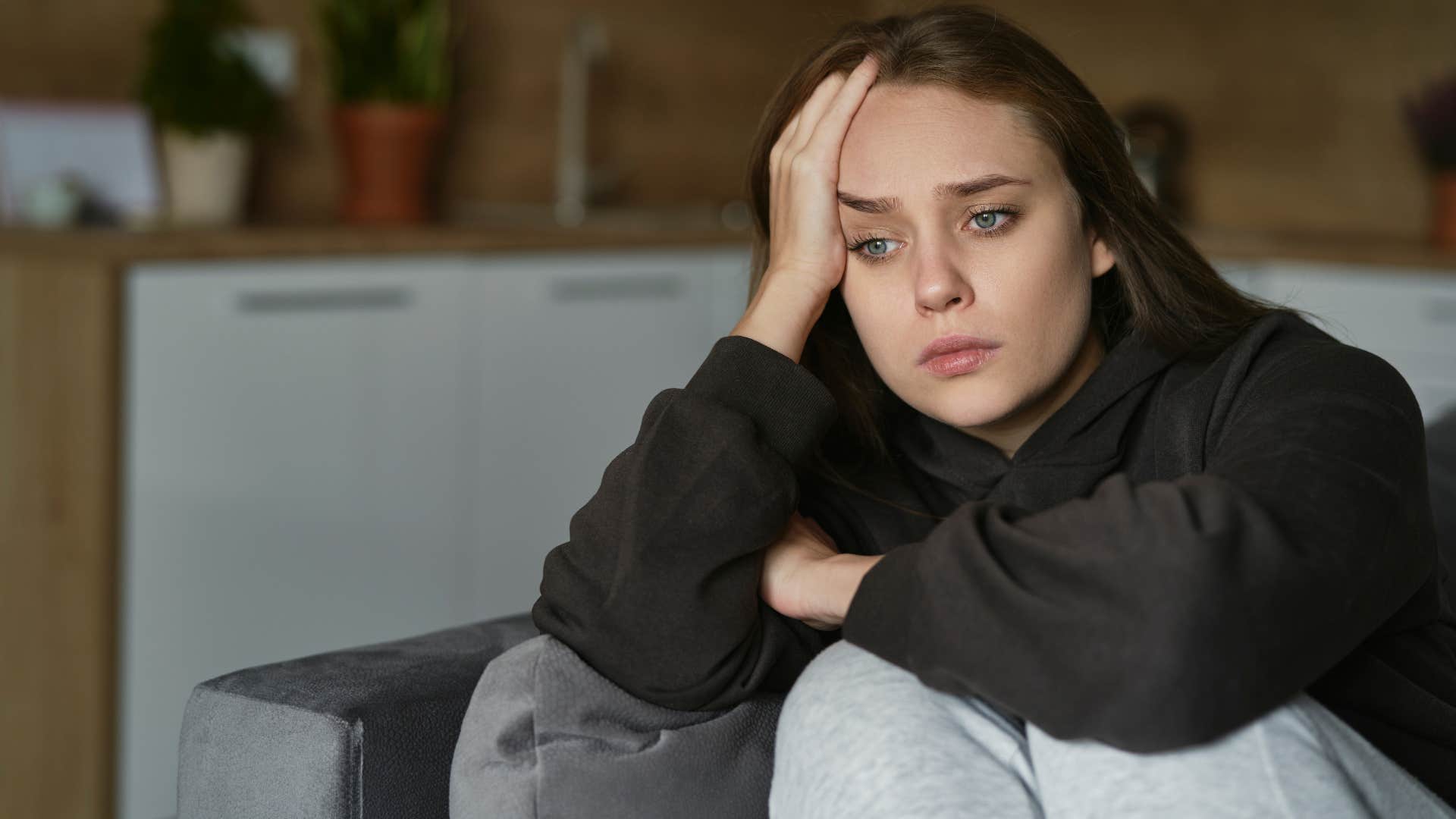 Woman suppressing complex emotions at home.