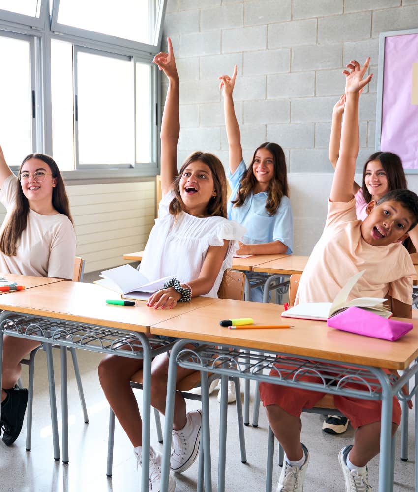 Happy students raise hands showing they are not absent