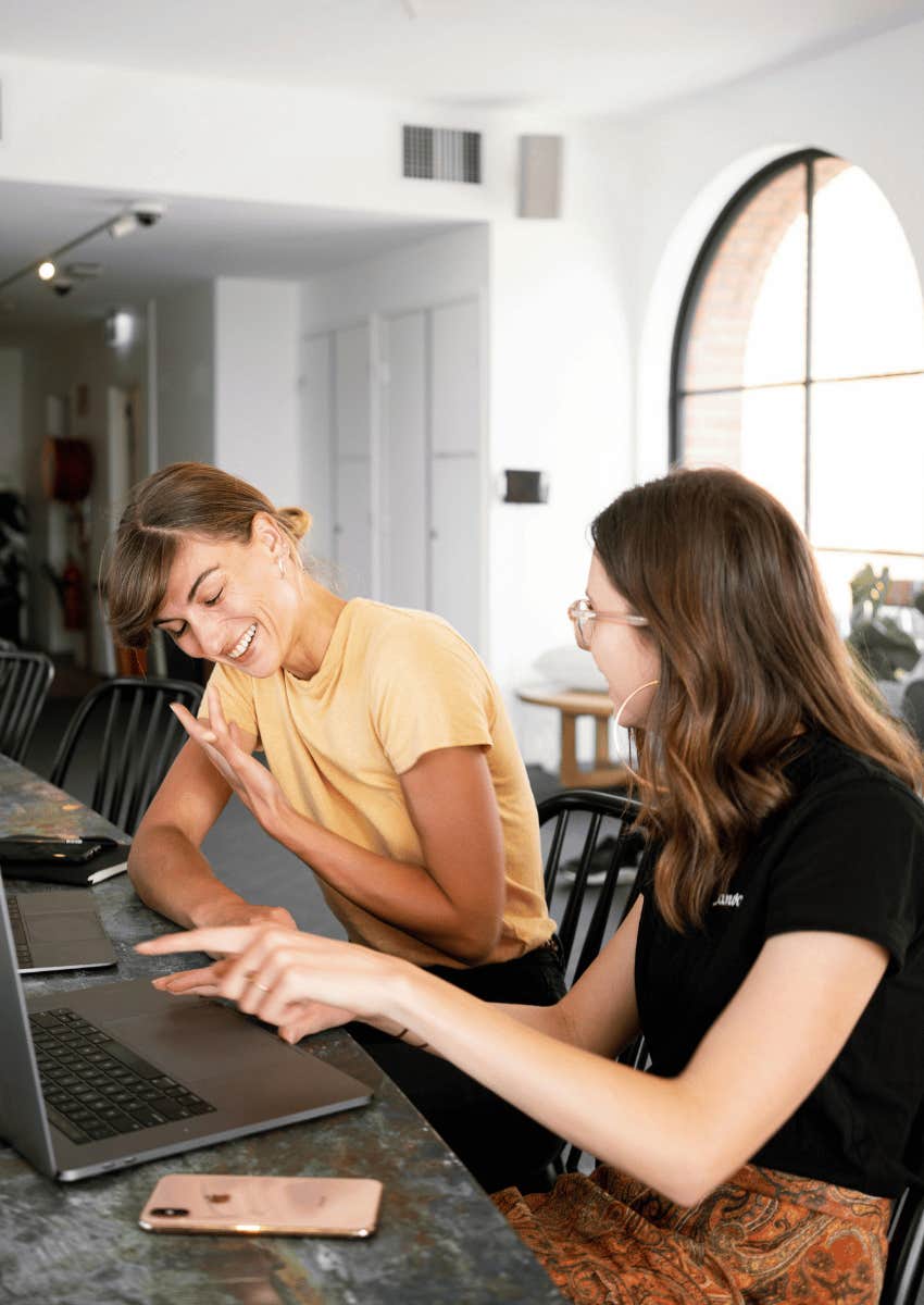 two happy coworkers sitting together