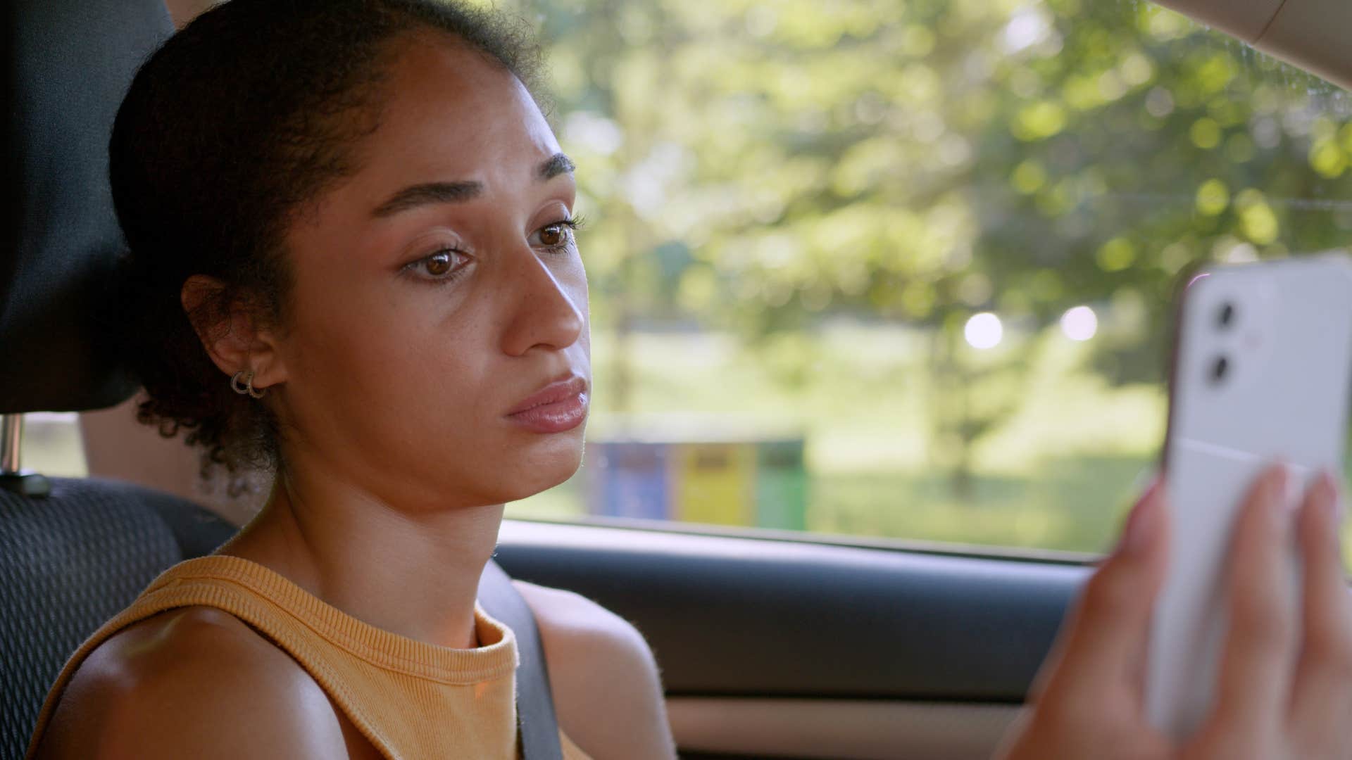 woman looking at her phone with someone who always creates unnecessary drama