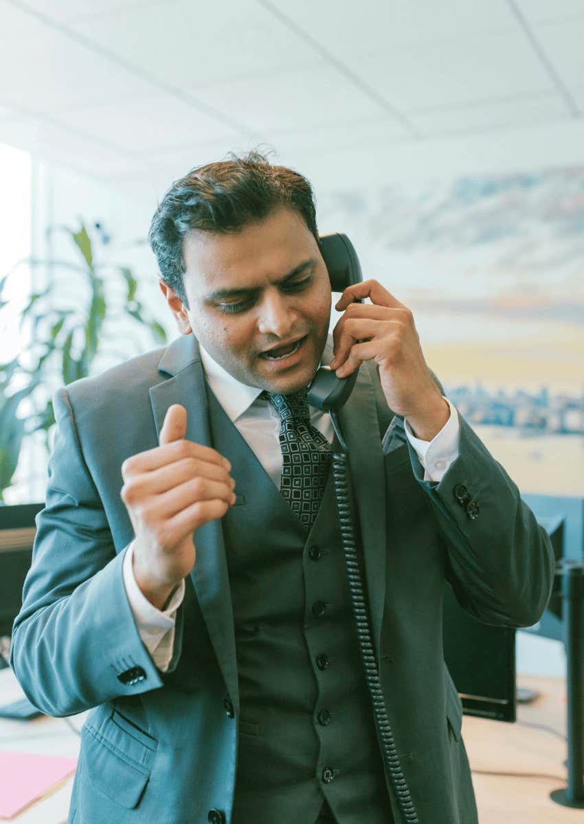 unhappy man wearing a suit talking on the phone