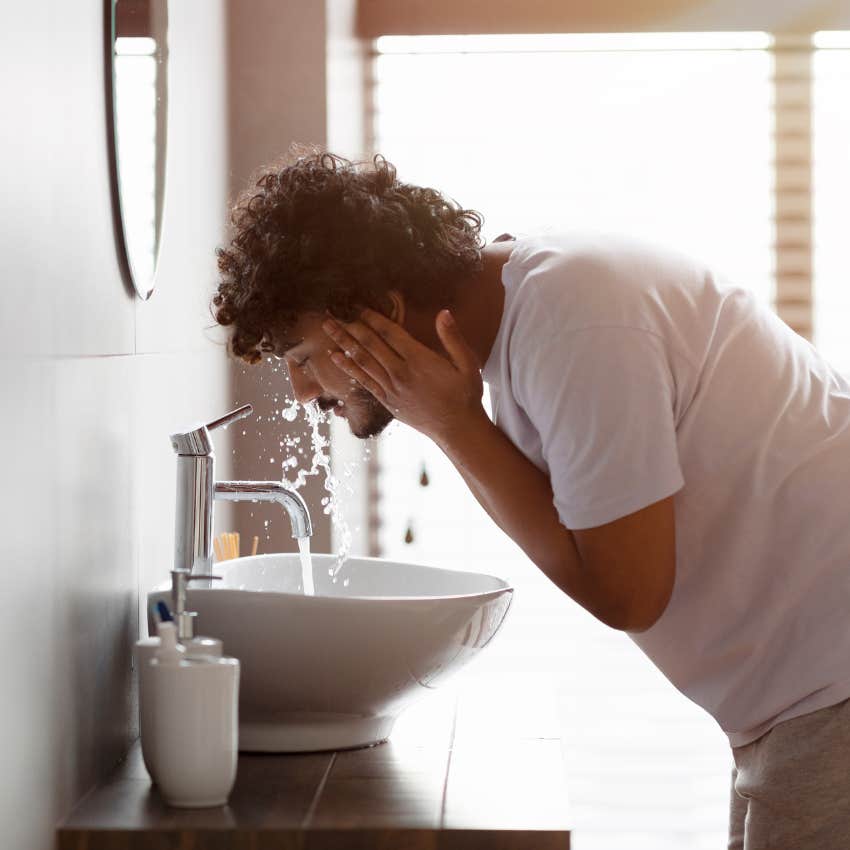 man washing face sink that he goes bathroom in to save money