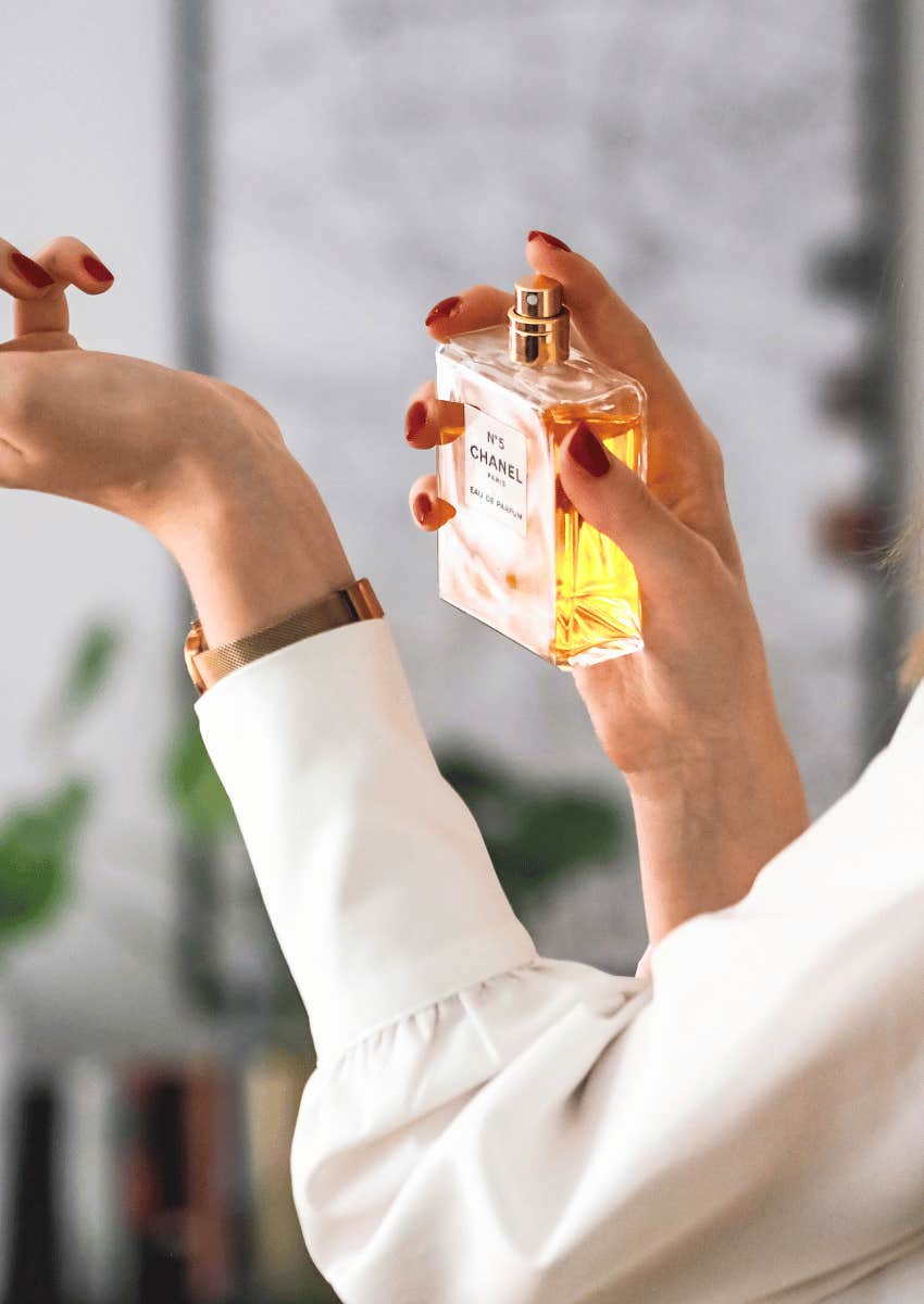 woman applying perfume to the inside of her wrist