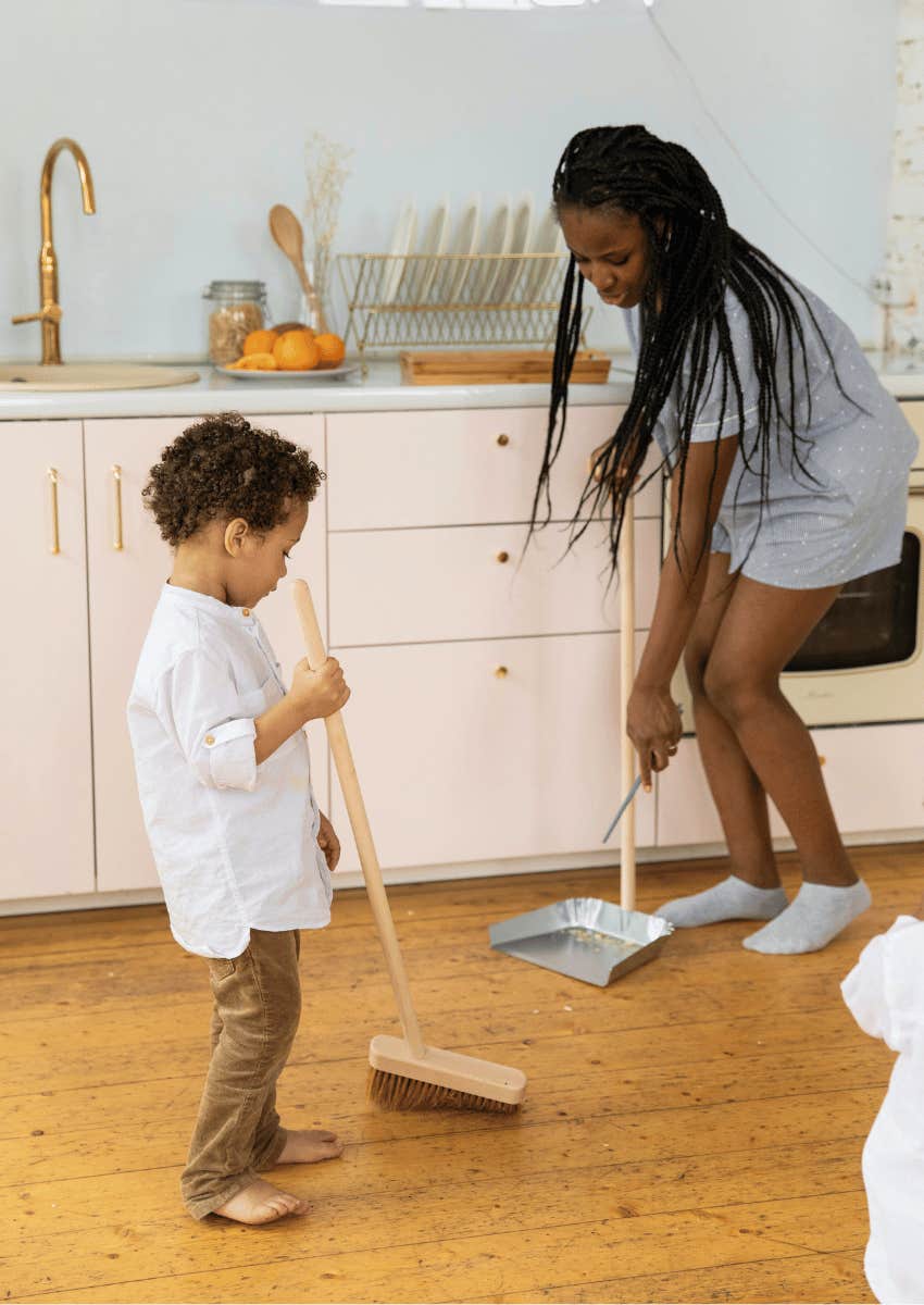 woman and child sweeping floor together
