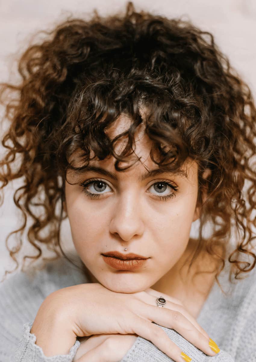 woman with curly hair with a serious expression