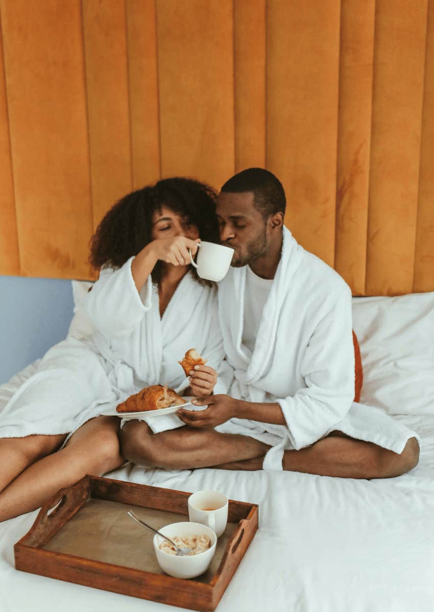 woman holding mug for man to drink from