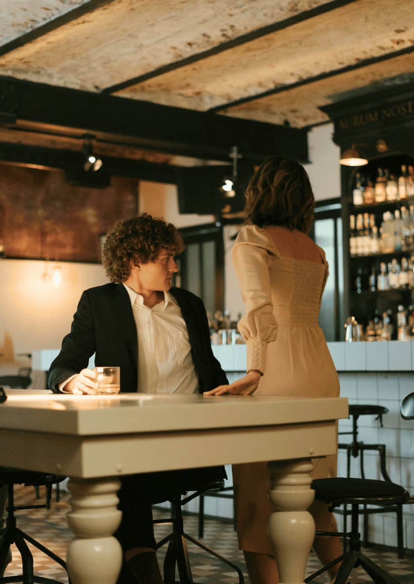 woman leaving table away from man