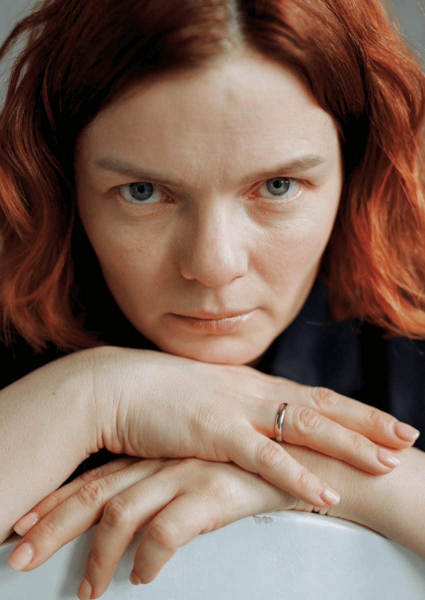 woman with red hair staring with a serious expression