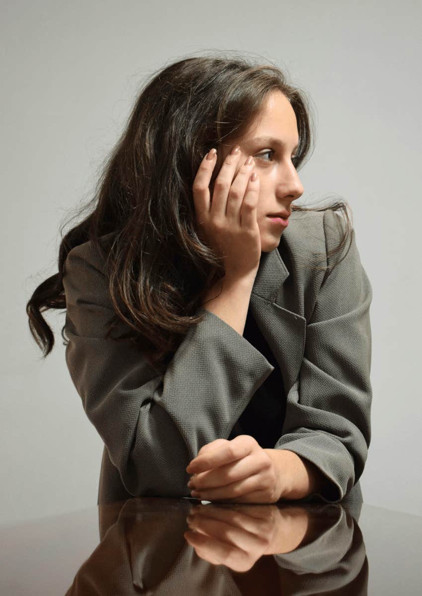 woman in a suit jacket with a serious expression