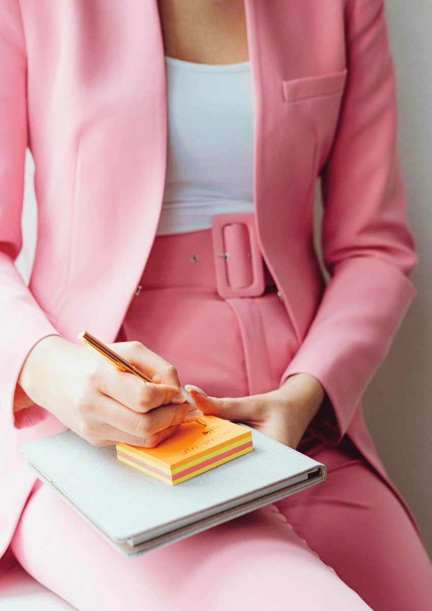 woman in a suit writing on sticky notes