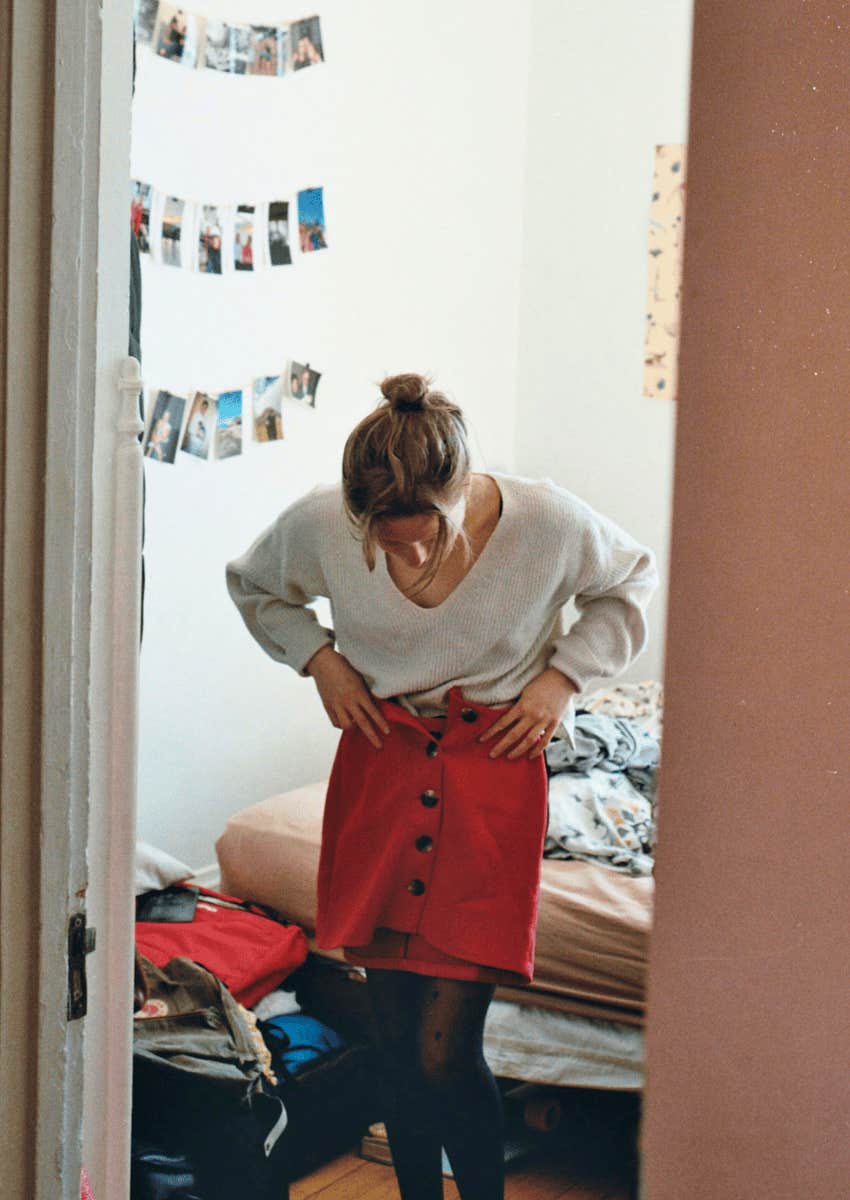 woman trying on clothes in her bedroom