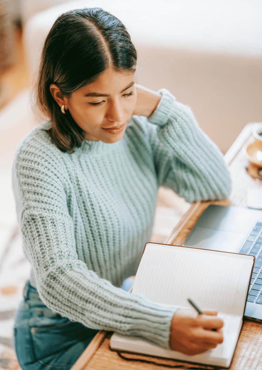woman writing in a personal notebook