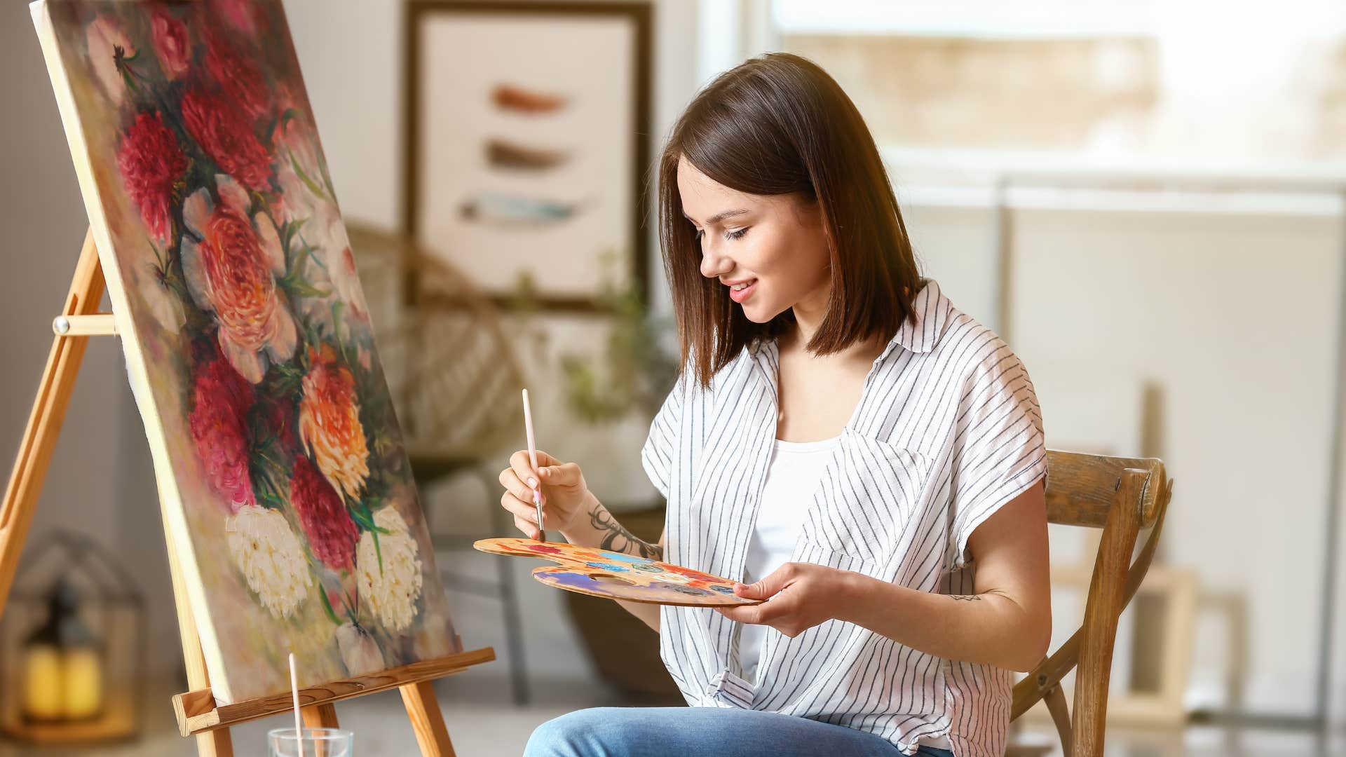 detail-oriented woman painting on canvas