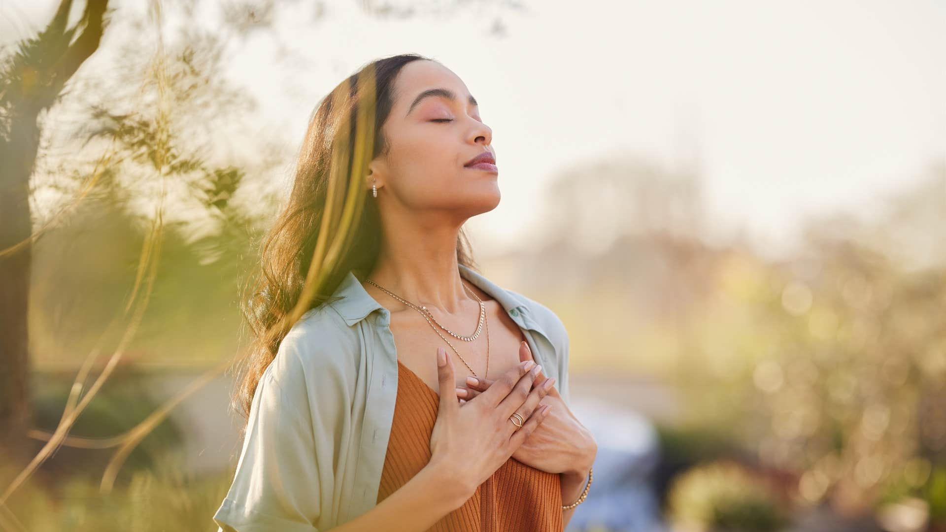 emotionally self-aware woman meditating outside