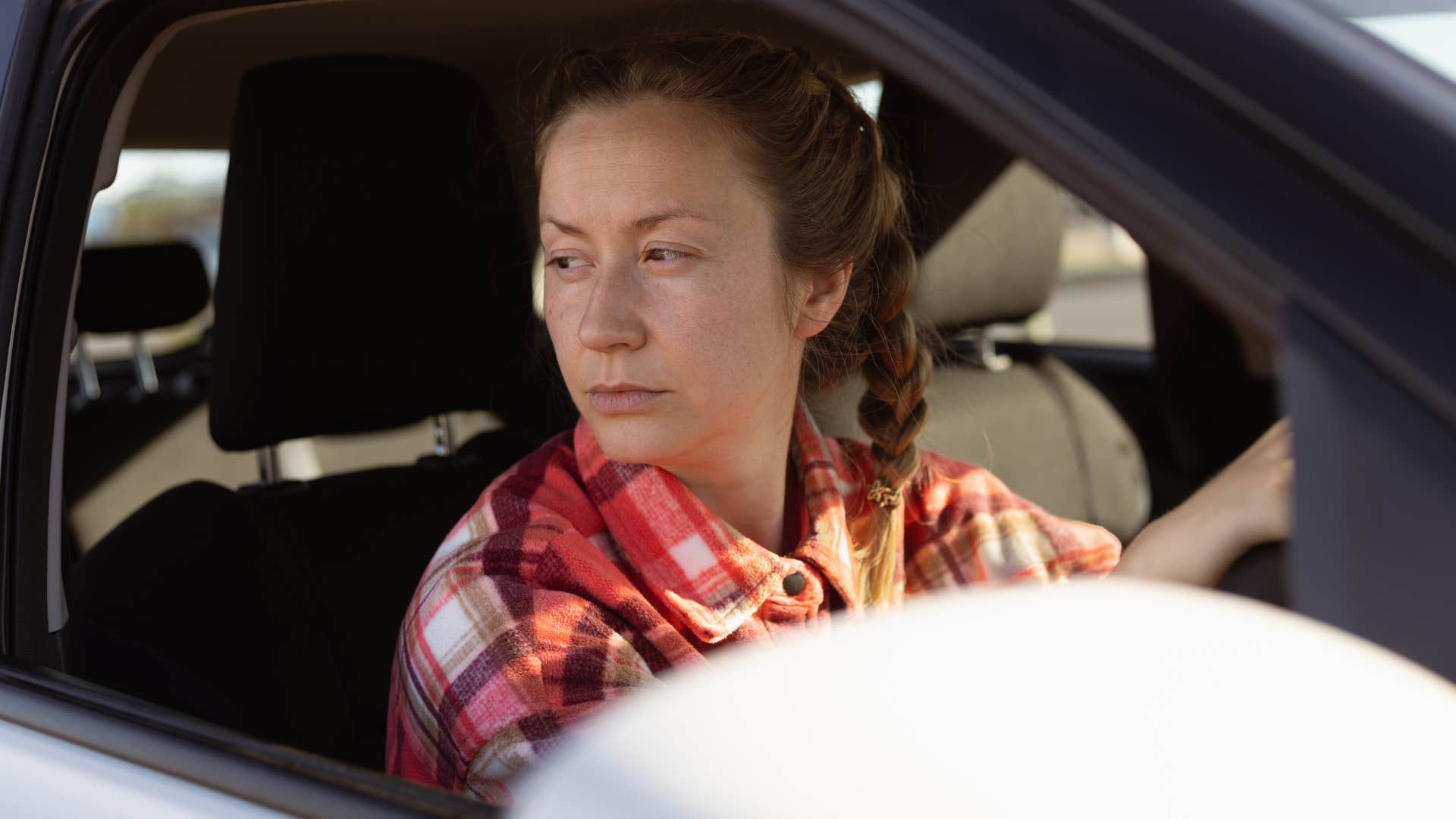 Woman who's always assuming the worst in her car.