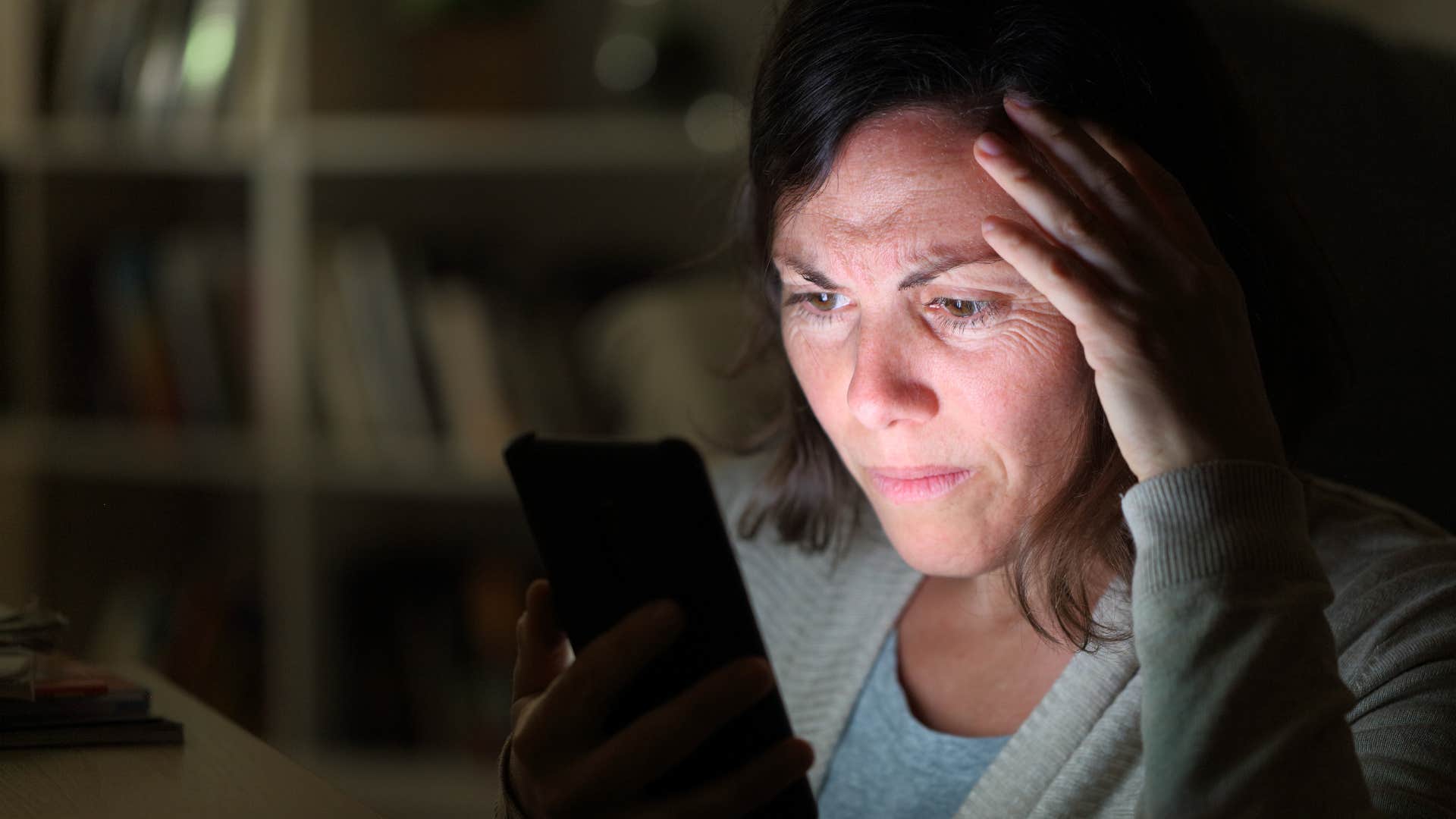 Woman who's an avid true crime watcher looking at her phone.