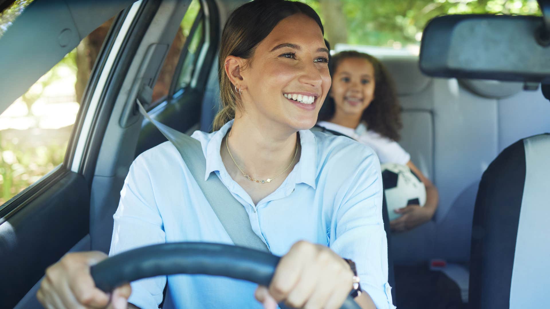 Woman who's a mother driving with her kids.