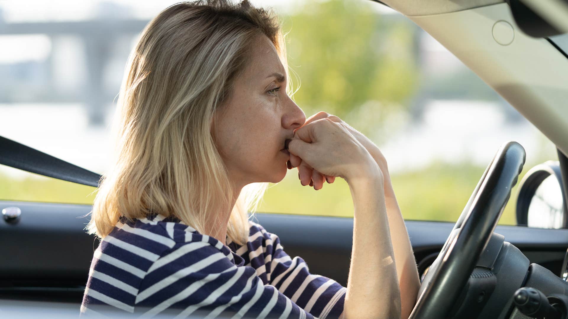 Woman who had unsafe experiences in the past driving her car.