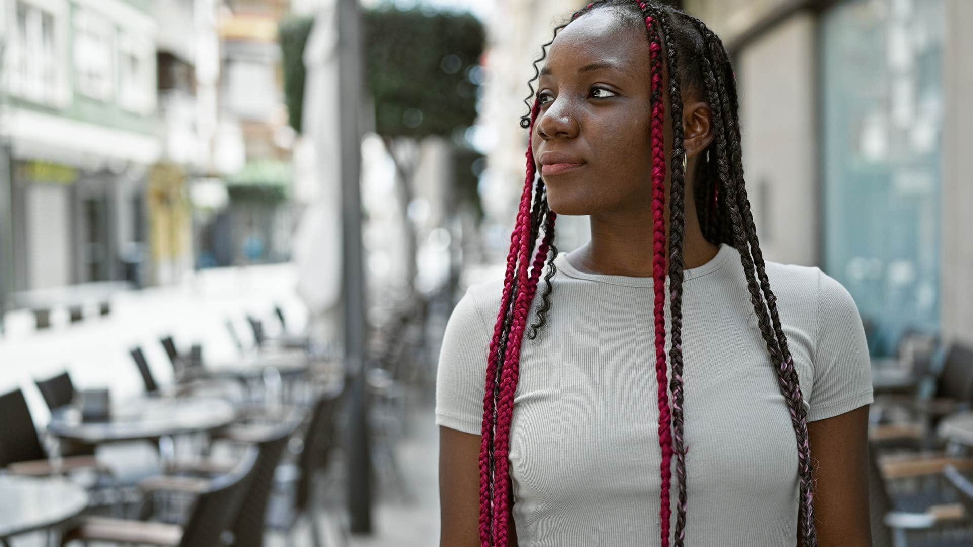 Woman who's used to protecting themselves standing outside.